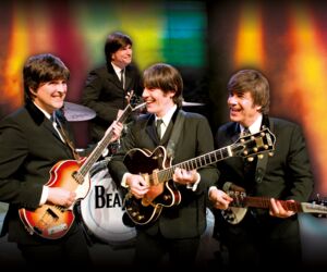 Die Beatles mit Instrumenten auf der Bühne