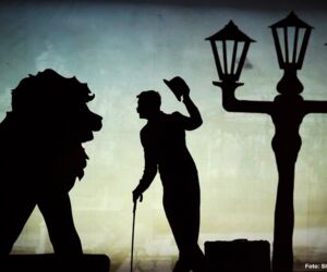 Schattenbild mit einer Person, einem Löwen und einer Straßenlaterne
