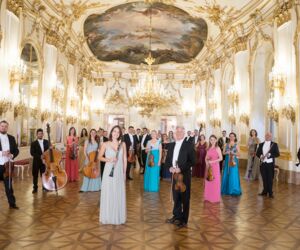 Schlossphilharmonisches Orchester Schönbrunn Wien stehend in einem prächtigen Saal
