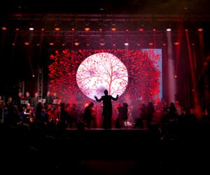 Das Orchester Lord of the Sound auf der Bühne mit rotem Hintergrund