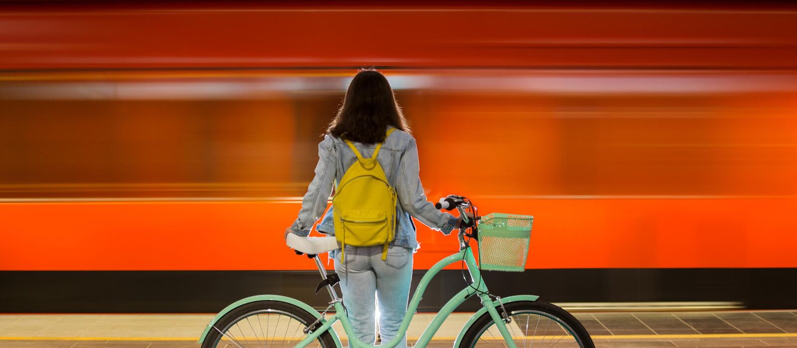 Frau mit dem Fahrrad an Bahnstation